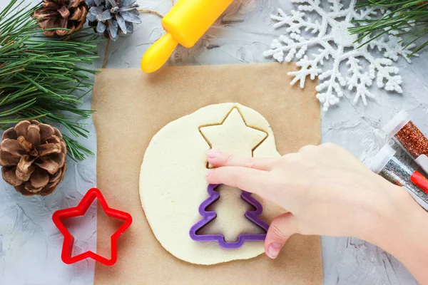 Küçük bir kızın eli Noel ağacında kendi elleriyle oyuncak yapıyor.