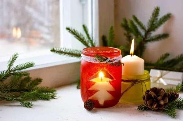 Noel ağacının dalları ve kırmızı ve altın rengi şamdanlardan yapılmış ev yapımı Noel süsleri..