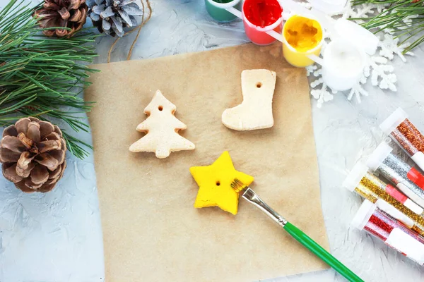 Рука рисует звезду желтой краской, игрушки на новый год своими руками, творческое оформление новогодней елки из соленого теста — стоковое фото