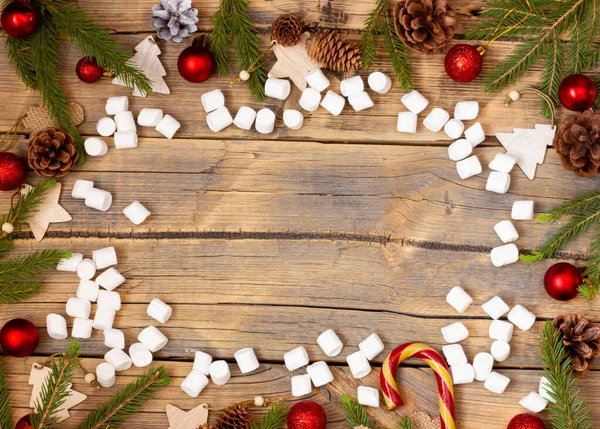 Disposición de Navidad sobre fondo de madera con bolas rojas, conos de pino y juguetes de madera, flatlay con decoraciones de Navidad y malvaviscos, lugar para el texto — Foto de Stock