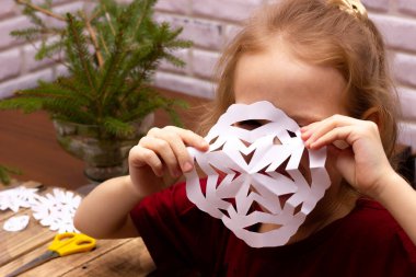 Kız, kendi elleriyle kestiği kar tanesinin arkasına saklanır ve yeni yıl için çocuklarla eğlenceli oyunlar oynar.