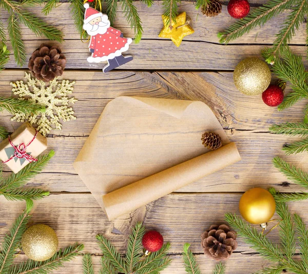 Mensaje sobre maqueta de papel artesanal en el centro de un círculo hecho de decoraciones navideñas y ramas de un árbol de Navidad sobre un fondo de madera — Foto de Stock