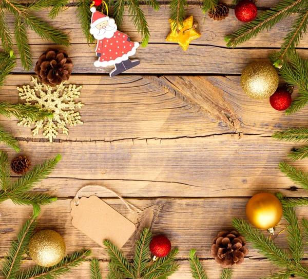 Espacio para texto en el centro de un círculo hecho de decoraciones navideñas y ramas de un árbol de Navidad sobre un fondo de madera — Foto de Stock