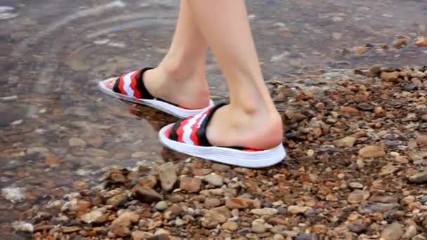 Pieds d'une fille en tongs rouges entrent dans l'eau par une chaude journée ensoleillée, au ralenti — Video