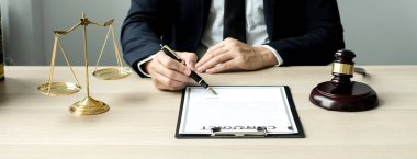 Profesyonel erkek avukatlar bir hukuk bürosunda çalışır. Teraziler, adalet terazileri, yargıç tokmağı ve dava belgeleri vardır. Hukuk ve adalet kavramları.