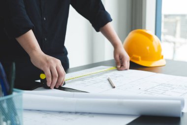 İnşaatta çalışan mimarlar ya da mühendisler inşaat planları, baskı, inşaat sahalarında yazılar çiziyor. Ev tasarımı kavramı.