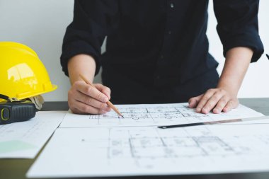 İnşaatta çalışan mimarlar ya da mühendisler inşaat planları, baskı, inşaat sahalarında yazılar çiziyor. Ev tasarımı kavramı.