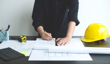 İnşaatta çalışan mimarlar ya da mühendisler inşaat planları, baskı, inşaat sahalarında yazılar çiziyor. Ev tasarımı kavramı.