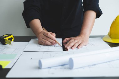 İnşaatta çalışan mimarlar ya da mühendisler inşaat planları, baskı, inşaat sahalarında yazılar çiziyor. Ev tasarımı kavramı.