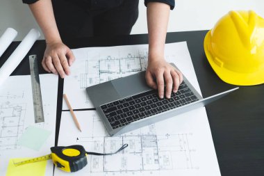 İnşaatta çalışan mimarlar ya da mühendisler inşaat planları, baskı, inşaat sahalarında yazılar çiziyor. Ev tasarımı kavramı.