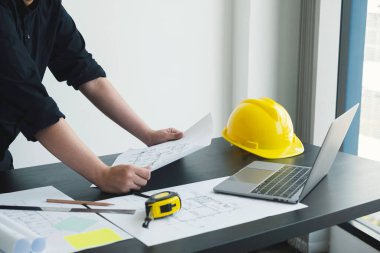 İnşaatta çalışan mimarlar ya da mühendisler inşaat planları, baskı, inşaat sahalarında yazılar çiziyor. Ev tasarımı kavramı.