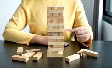 Ahşap blok oyunu oynayan iş kadınlarının elleri. Ticari büyüme ve başarı için yönetim riski ve strateji planlarını kabul et.