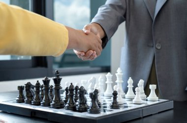 Satranç yarışmalarında satranç oynayan iki kişi liderlik, takipçiler ve stratejik planlar, iş başarısı oluşturma süreçleri ve takım çalışmalarını gösteriyor..