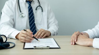 Erkek doktorlar, bir kadın hasta bir doktorla tanışıp hastalık sorunlarıyla ilgili sonuçlar aldıktan sonra tedavi öneriyor. Tıbbi ve sağlık hizmetleri kavramları.