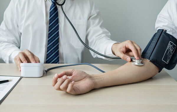 Man doctors measured blood pressure, the patient examined the heartbeat, and talked about health care closely. Medical and health care concepts.