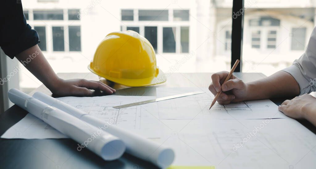 Team of engineers and architects, working team, meeting, discussing construction and drawing construction plans, printing, writing on-site construction sites. Home design concept.