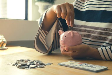 Kadın eli. Bozuk paralarla kumbaraya para koymak, madeni paralarla para biriktirmek, başarılı bir büyüyen işe girmek ve emeklilik için para biriktirmek. Emeklilik tasarruf kavramı.