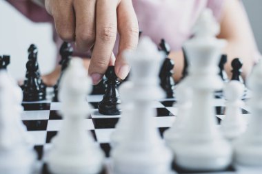 Hareket eden iş kadını eli, rekabetteki satranç liderlik, takipçiler ve ticari başarı stratejilerini gösteriyor.