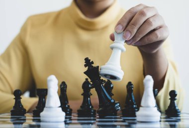 Hareket eden iş kadını eli, rekabetteki satranç liderlik, takipçiler ve ticari başarı stratejilerini gösteriyor.