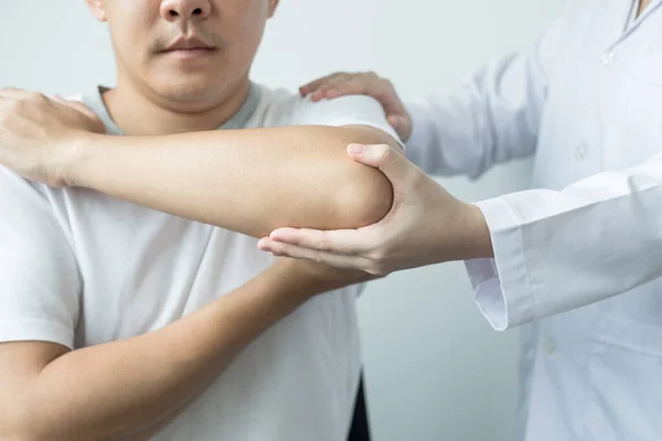 Γυναίκες Φυσικοθεραπευτές Παρέχουν Βοήθεια Άνδρες Ασθενείς Κακώσεις Αγκώνα Εξετάσει Ασθενείς — Φωτογραφία Αρχείου