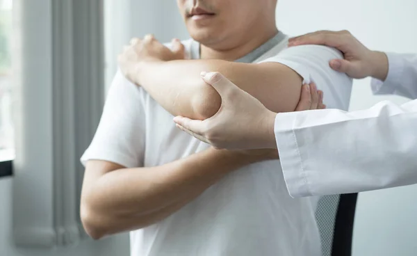 Γυναίκες Φυσικοθεραπευτές Παρέχουν Βοήθεια Άνδρες Ασθενείς Κακώσεις Αγκώνα Εξετάσει Ασθενείς — Φωτογραφία Αρχείου
