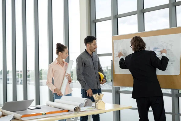 Erkek ve kadın mühendisler ve mimarlardan oluşan bir ekip, çalışma ekibi, inşaat planlarını tartışıyor ve çiziyor, baskı yapıyor, inşaat alanlarında yazıyor..