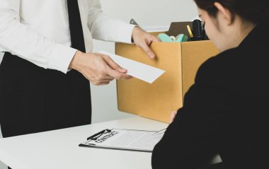Umutsuzca kovulan bir ofis çalışanı işverenine istifa mektubunu verir ve eşyalarını karton kutu konseptine koyar..