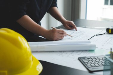 İnşaatta çalışan mimarlar ya da mühendisler inşaat planları, baskı, inşaat sahalarında yazılar çiziyor. Ev tasarımı kavramı.