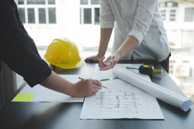Mühendisler ve mimarlardan oluşan bir ekip, çalışma ekibi, toplantı, inşaat planları ve çizim planları, baskı, inşaat alanlarında yazma konuları. Ev tasarımı kavramı.