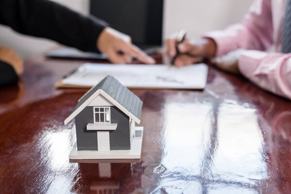 Real estate agent broker hand over the home to the new owner after completing the signing according to agreement renting a house and buy house insurance Home insurance concept.