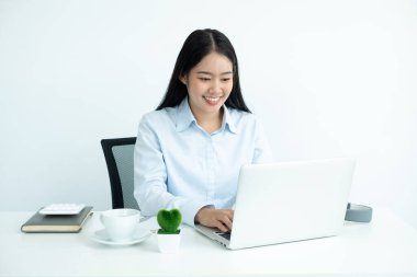 Bilgisayarda çalışan Asyalı kadın. Ofiste çalışan başarılı bir gülümseyen iş kadını..
