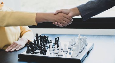 Satranç yarışmalarında satranç oynayan iki kişi liderlik, takipçiler ve stratejik planlar, iş başarısı oluşturma süreçleri ve takım çalışmalarını gösteriyor..