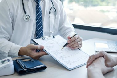 Erkek doktorlar, bir kadın hasta bir doktorla tanışıp hastalık sorunlarıyla ilgili sonuçlar aldıktan sonra tedavi öneriyor. Tıbbi ve sağlık hizmetleri kavramları.