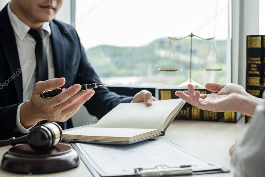 Male lawyers or a judge counseling clients about judicial justice and prosecution with scales, judges gavel, legal documents legal services concept.