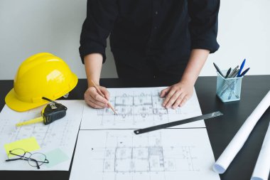 İnşaatta çalışan mimarlar ya da mühendisler inşaat planları, baskı, inşaat sahalarında yazılar çiziyor. Ev tasarımı kavramı.