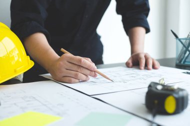 İnşaatta çalışan mimarlar ya da mühendisler inşaat planları, baskı, inşaat sahalarında yazılar çiziyor. Ev tasarımı kavramı.