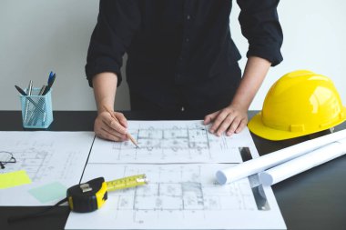 İnşaatta çalışan mimarlar ya da mühendisler inşaat planları, baskı, inşaat sahalarında yazılar çiziyor. Ev tasarımı kavramı.