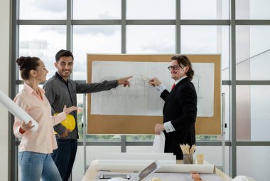 Erkek ve kadın mühendisler ve mimarlardan oluşan bir ekip, çalışma ekibi, inşaat planlarını tartışıyor ve çiziyor, baskı yapıyor, inşaat alanlarında yazıyor..