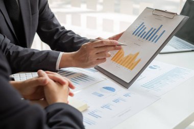 İş dünyası liderleri grafikler, finansal grafikler hakkında konuşuyor. Sonuçlar, planlama stratejilerini analiz ediyor ve hesaplıyor. İş başarısı oluşturma süreçleri..