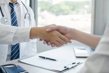 Hasta tedavisini bitirdikten sonra doktorlar ve erkek hastalar el sıkışıyor. Tıbbi kavramlar ve sağlık.