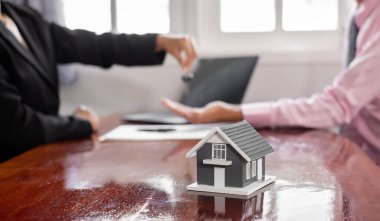 Emlak komisyoncusu imzayı attıktan sonra evin anahtarını ev kiralama ve ev sigortası konseptini satın alma anlaşmasına göre yeni sahibine teslim etti..