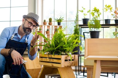 Bıyıklı, yaşlı ve yakışıklı bir adam ağaç bakımıyla mutlu olur. Evde bahçıvanlık hobisi. Emeklilikten sonra mutlu yaşamak. Doğa ve çevre kavramları.