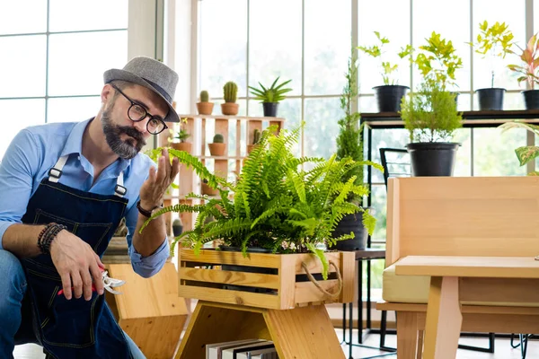 Bıyıklı, yaşlı ve yakışıklı bir adam ağaç bakımıyla mutlu olur. Evde bahçıvanlık hobisi. Emeklilikten sonra mutlu yaşamak. Doğa ve çevre kavramları.