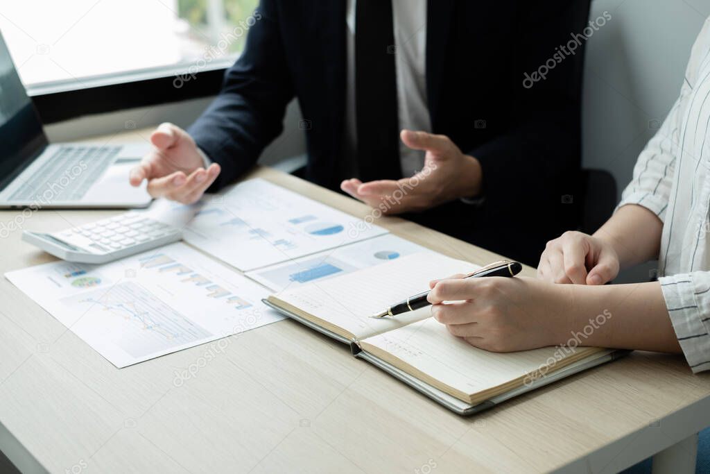 Two business leaders talk about charts, financial graphs showing results are analyzing and calculating planning strategies, business success building processes.