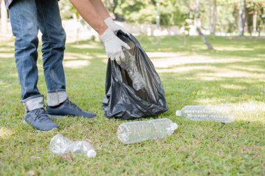 Çöp toplama, insanların elleri plastik şişeleri toplar, çöpleri parkları temizlemek, kirlilikten kaçınmak, çevreye ve ekosisteme dost olmak için siyah çöp torbalarına koyar..