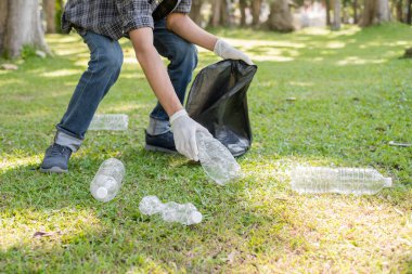 Çöp toplama, insanların elleri plastik şişeleri toplar, çöpleri parkları temizlemek, kirlilikten kaçınmak, çevreye ve ekosisteme dost olmak için siyah çöp torbalarına koyar..