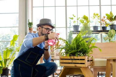 Bıyıklı, yaşlı ve yakışıklı bir adam ağaç bakımıyla mutlu olur. Evde bahçıvanlık hobisi. Emeklilikten sonra mutlu yaşamak. Doğa ve çevre kavramları.
