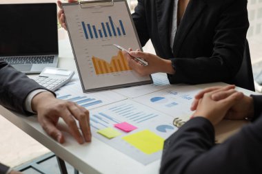 İş dünyası liderleri grafikler, finansal grafikler hakkında konuşuyor. Sonuçlar, planlama stratejilerini analiz ediyor ve hesaplıyor. İş başarısı oluşturma süreçleri..