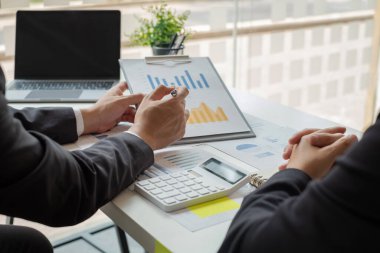 İş dünyası liderleri grafikler, finansal grafikler hakkında konuşuyor. Sonuçlar, planlama stratejilerini analiz ediyor ve hesaplıyor. İş başarısı oluşturma süreçleri..