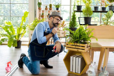 Bıyıklı, yaşlı ve yakışıklı bir adam ağaç bakımıyla mutlu olur. Evde bahçıvanlık hobisi. Emeklilikten sonra mutlu yaşamak. Doğa ve çevre kavramları.